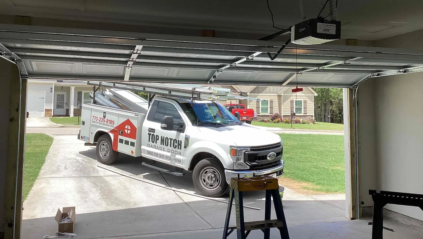 Top Notch Garage Door truck near house after receiving garage door coupons